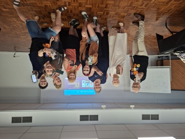 A video course group in class, holding up their phones after an editing session